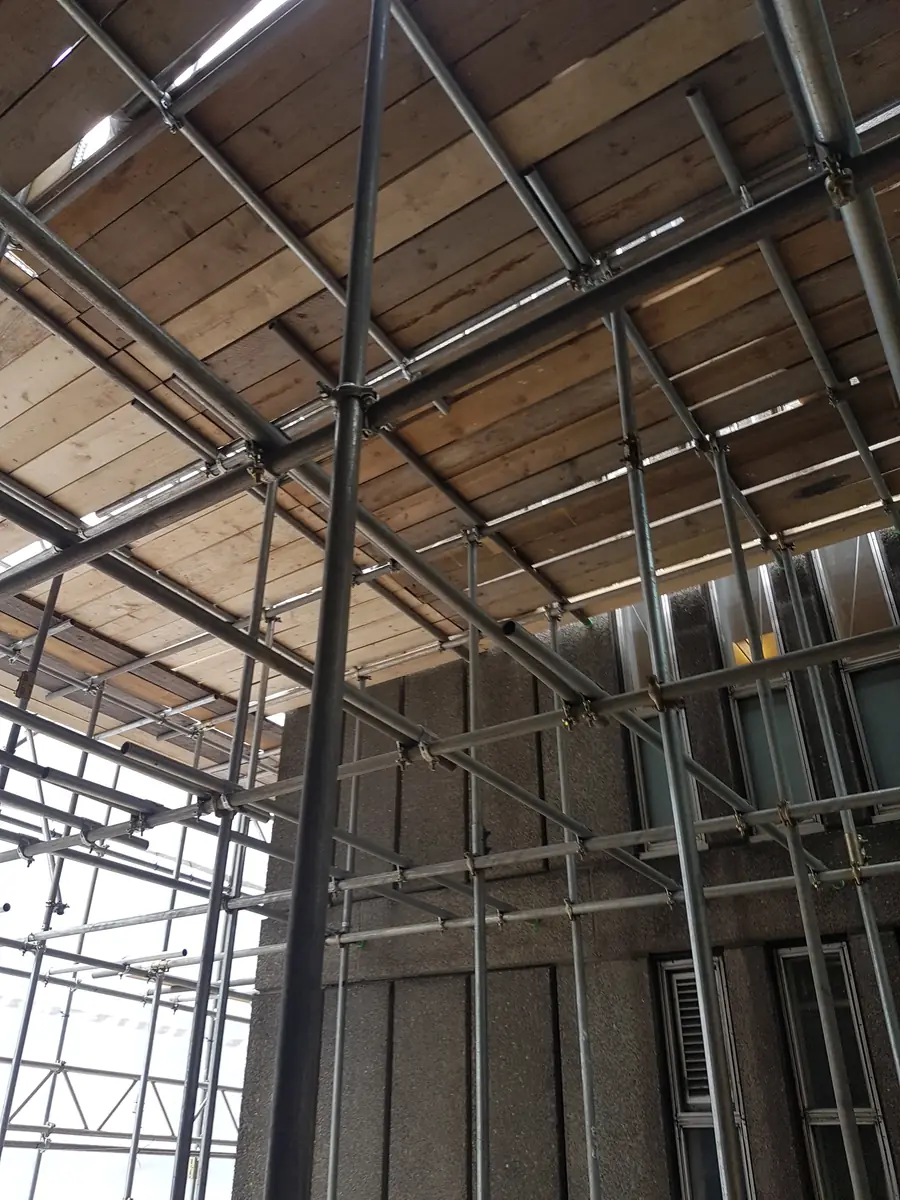 Looking up at the boarded underside of a scaffold deck