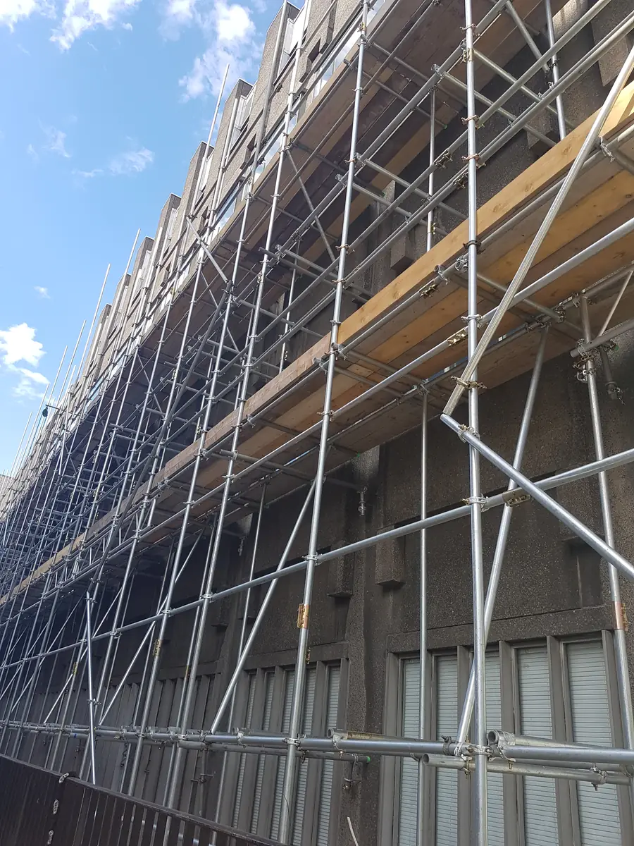 Boarded scaffold lifts along a building