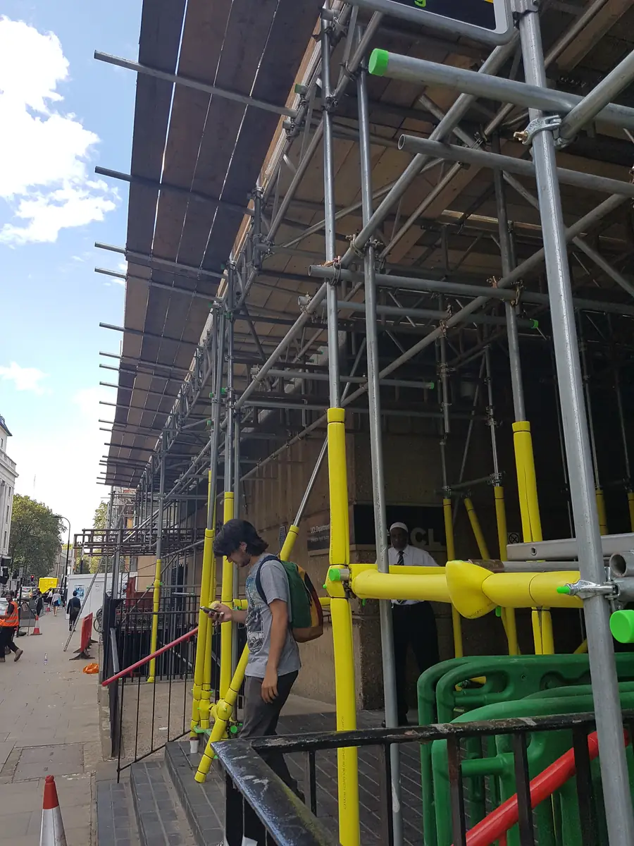 Scaffold over a pavement with a covered walkway